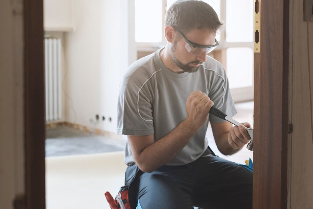 Carpenter removing an old door at home